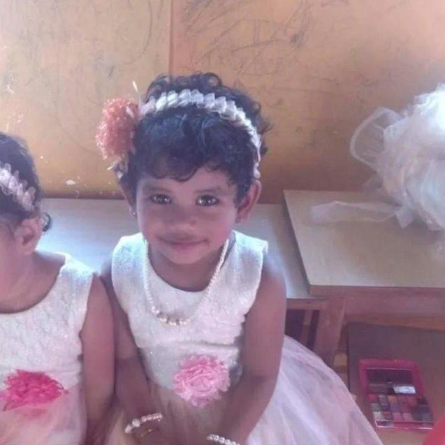 Raziel in a white party dress and flower headband