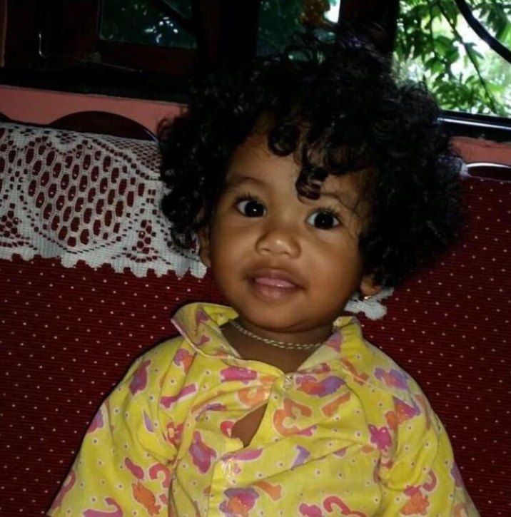 A smiling toddler with curly hair