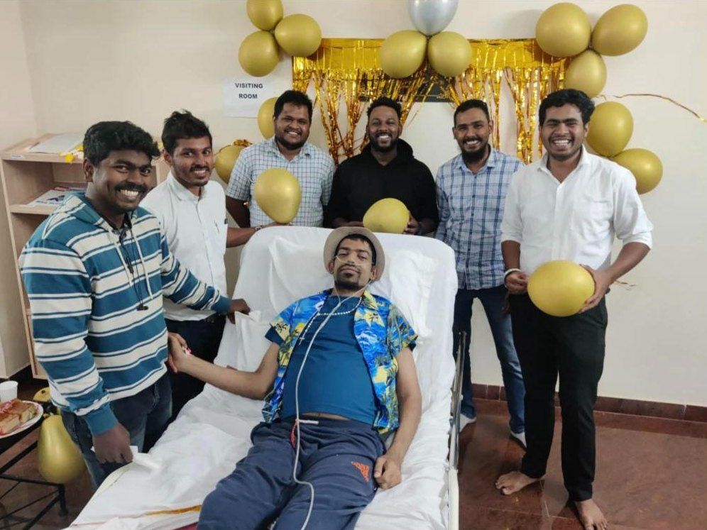 Friends and volunteers celebrating with a patient on the ward